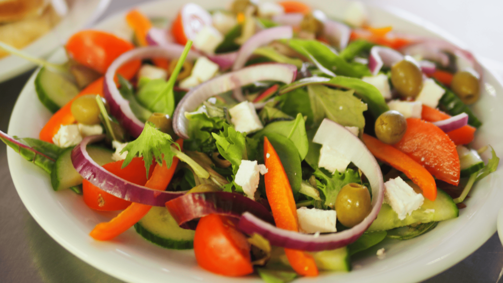 Top 10 alimentos para o cutting. Imagem de prato com salada de diversos legumes e verduras.