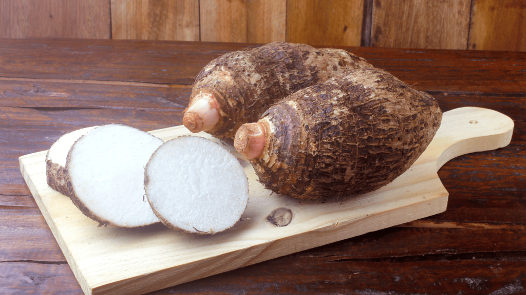 Top 10 alimentos para o cutting. Imagem de tábua de madeira com dois inhames inteiros e um partido em fatias.